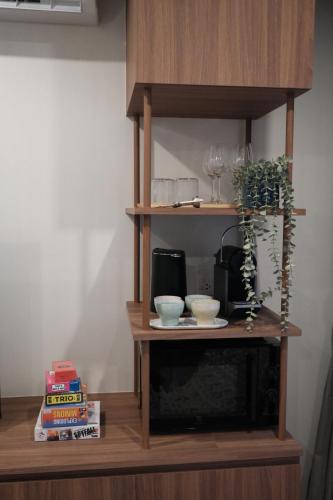 a shelf with bowls and a plant on it at The Shantipan Jasmine - Cozy City Retreat 400m from BTS Station in Bangkok
