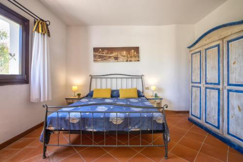 een slaapkamer met een blauw bed met 2 gele kussens bij Trilocale Fiordaliso in Stintino