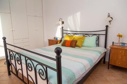a bedroom with a bed with colorful pillows on it at Waterfront Bliss in Diakofti, Kythira 2 Bedroom in Dhiakofti