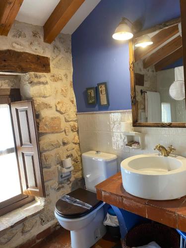 a bathroom with a sink and a toilet and a mirror at El Corral De Perorrubio in Perorrubio