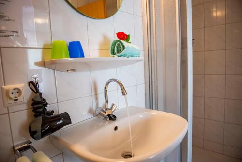 a white sink in a bathroom next to a shower at Landgasthaus Kaster in Valwig