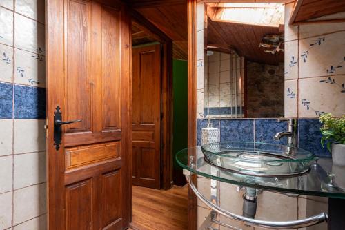 a bathroom with a glass sink and a wooden door at Montegrande rodeado de montañas in Páramo