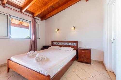 a bedroom with a bed with white sheets and a window at Alex bar apartments in Sarakiniko