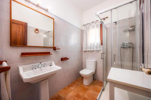 Un baño con lavabo, inodoro y ducha. en Es Quarteró, en Sóller