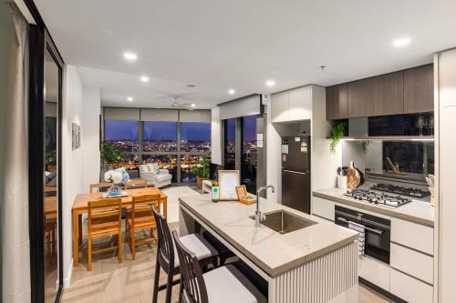 ブリスベンにあるCity Beach Brisbane Queens Wharf -Spectacular River Views - Sleeps 6の街の景色を望むキッチンとダイニングルーム