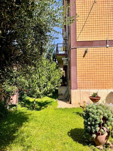 a yard with grass and trees and a building at Tor Vergata Smart Living in Rome