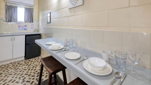 a kitchen with a table with plates and glasses on it at Waterview Motel Maclean in Maclean