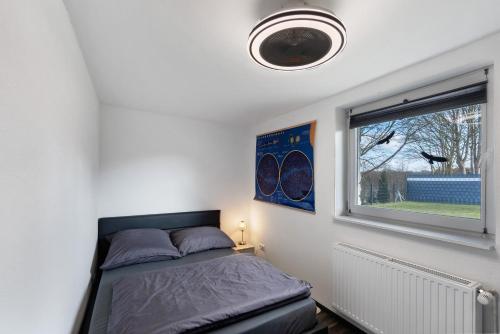 a bedroom with a bed and a window at Deluxe Fewo zw Plöner See u Ostsee in Nehmten