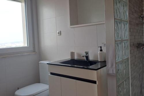 a bathroom with a sink and a toilet at Casa Condor - Moradia com piscina a 5 min da praia in Lourinhã
