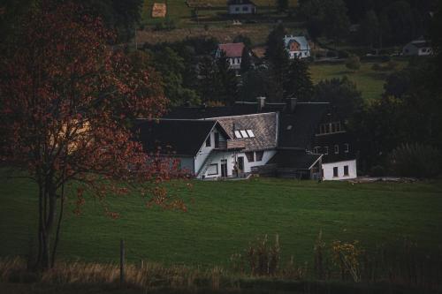 a white house on a hill with a green field at Landhaus Bärenstein - Pano-Blick 1 in Bärenstein