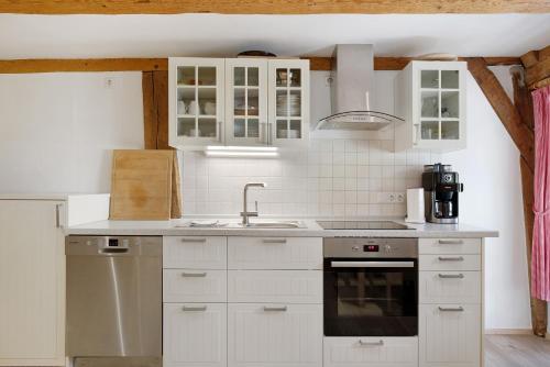 a kitchen with white cabinets and a sink at Müllerjörgenhof in Gutach