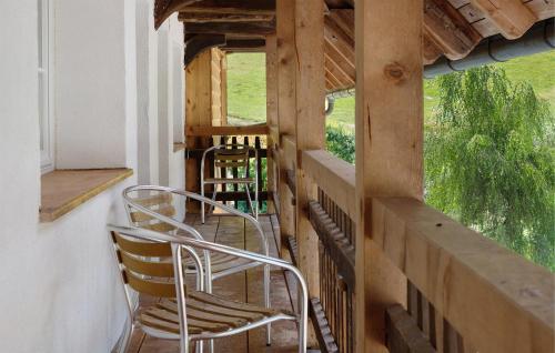 a porch with two chairs and a table and two windows at Müllerjörgenhof in Gutach