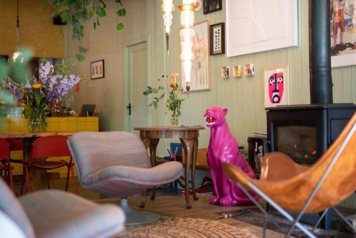 a room with chairs and a table and a pink dog at Fort Vuren in Vuren