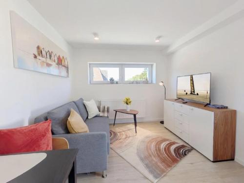 a living room with a couch and a tv at Ferienwohnung Emilia 2 in Garding