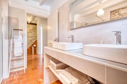 ein Badezimmer mit zwei Waschbecken und einem großen Spiegel in der Unterkunft Maison de Campagne à Cunèges in Cunèges