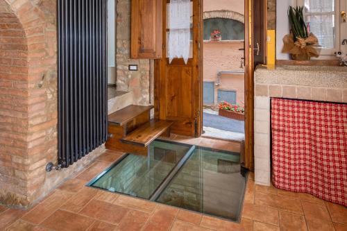 a glass floor in a room with a door at Casa Antica Tuscany in Chianni