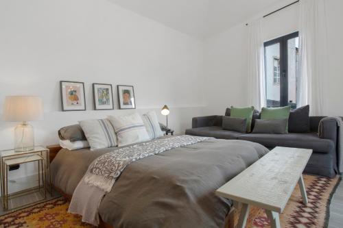 a bedroom with a large bed and a couch at The Village Loft in Caniço
