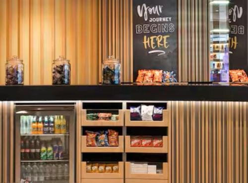 a counter in a store with a refrigerator with food at Hampton By Hilton Wroclaw Airport in Wrocław