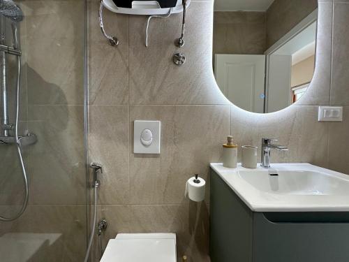 a bathroom with a shower and a sink and a mirror at Apartments 16th Street in Mostar