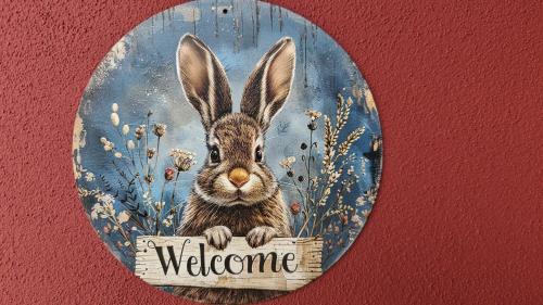 Una imagen de un conejo sosteniendo un cartel de bienvenida. en La Hasienda, en Geldern