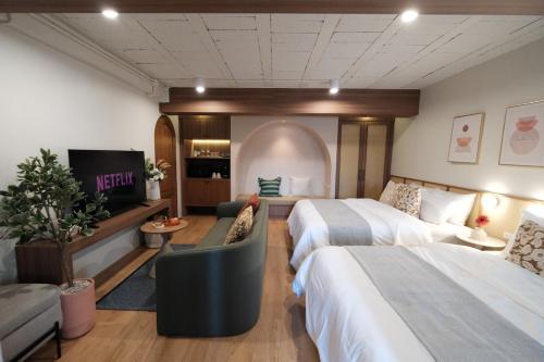 a hotel room with two beds and a tv at The Shantipan Mandala - Cozy City Retreat 400m from BTS Station in Bangkok