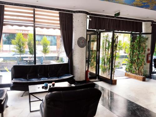 a living room with a couch and some windows at NESCLASS OTeLl in Kusadası