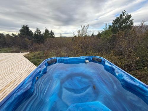 a blue tub sitting on top of a wooden deck at Discover Iceland Private Lodges Two Houses in Blaskogabyggd