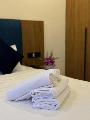 a pile of towels sitting on top of a bed at Ross Harriet View in Port Blair