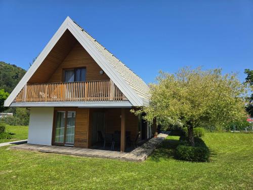 a house with a deck and a tree at Apartma Pikabooth in Topolšica
