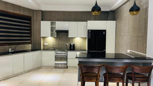 キャンディにあるHanthana Luxury Homestayのキッチン(白いキャビネット、黒いカウンタートップ付)