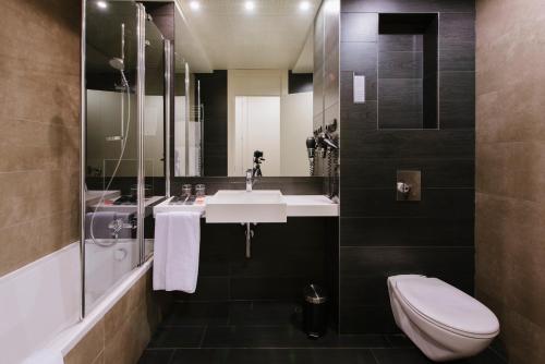 
a bathroom with a toilet, sink, and bathtub at PCM Forum Alcalá in Alcalá de Henares
