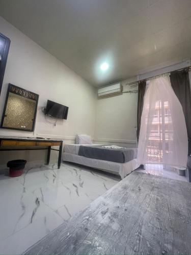a bedroom with a bed and a tv and a table at One Season Hotel in Cairo