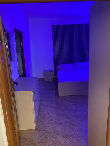 a blue room with a bed and a couch at Jaupaj Rent House in Vlorë