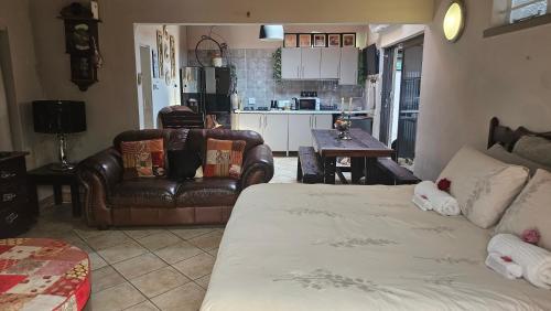 ein Wohnzimmer mit einer Couch, einem Sessel und einem Tisch in der Unterkunft Rose Cottage Vintage room in Pretoria