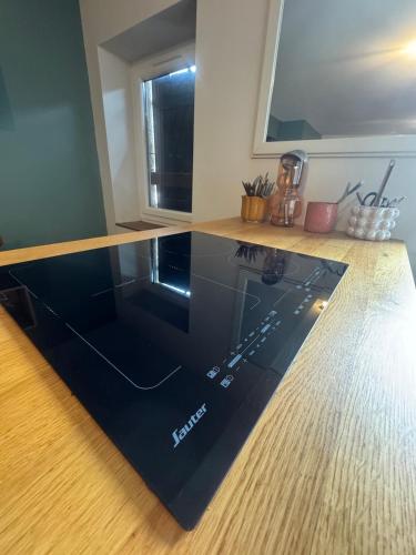 a kitchen with a glass counter top on a wooden floor at Modern and old T2 in Condrieu