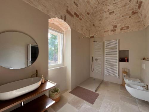 a bathroom with a tub and a sink and a mirror at Cascina Filomena in Polignano a Mare