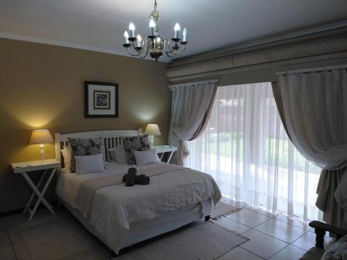 a bedroom with a bed with a teddy bear on it at Cranberry Cottage in Kathu