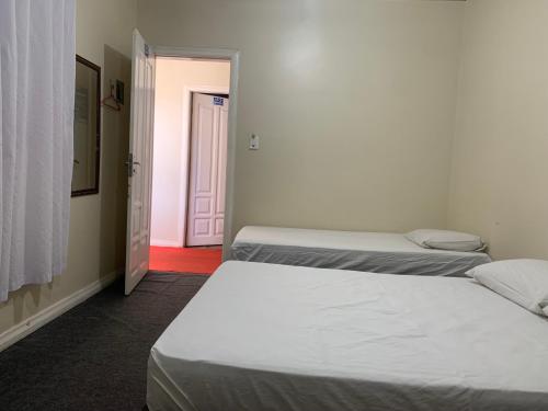 two beds in a room with a door leading to a bedroom at Hotel Casa do Ivo Orla in Santarém