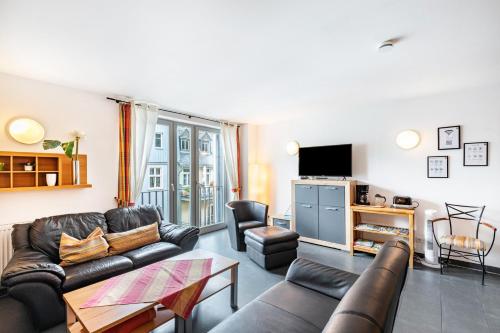 a living room with a couch and a tv at Bacchus Holiday Homes in Bacharach