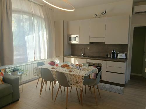 a kitchen with a table and chairs and a kitchen with white cabinets at A Casa di Raffi by Holiday World in Pisogne