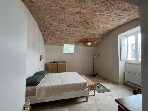 a bedroom with a bed and a brick ceiling at Cascina Filomena in Polignano a Mare