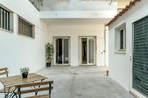 a patio with a wooden bench and a table at Estrela House by Homing in Lisbon