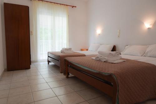 una camera da letto con due letti con asciugamani sopra di Prionas Studios a Paralía Skotínis