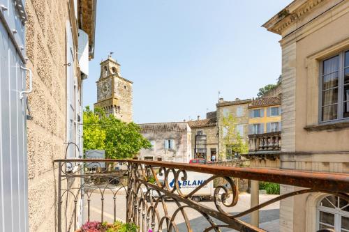 a balcony of a building with a clock tower at Logis Hôtel La Bastide De Grignan & Restaurant "La Chênaie" in Grignan