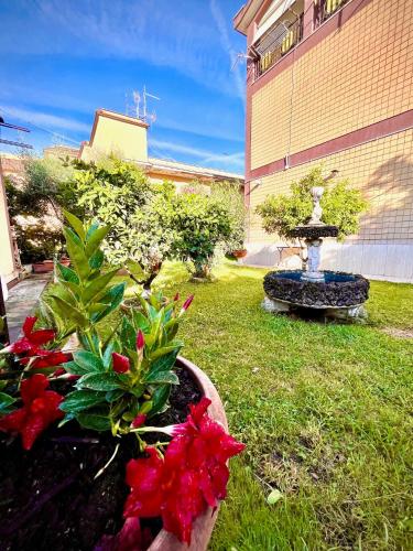 a garden with a fountain and flowers in the grass at Tor Vergata Smart Living in Rome