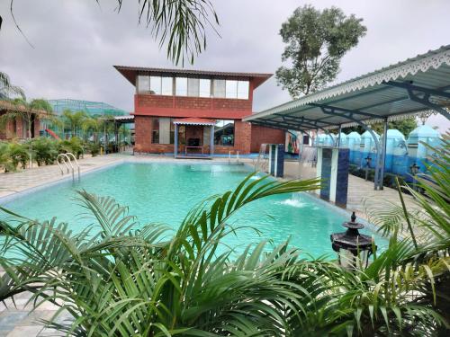 a large swimming pool in front of a building at Sandalwoods Resort in Neral