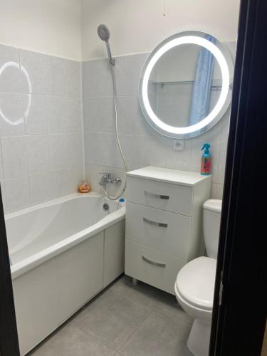 a bathroom with a tub and a toilet and a mirror at Апарт Безручка in Rivne