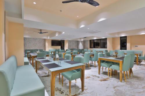 a dining room with tables and chairs at Empyrean Resort in Gandhinagar