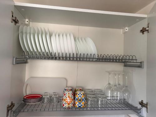 un frigorifero con bicchieri da vino e piatti su uno scaffale di La casetta della piazza a Carovigno