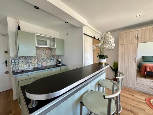 a kitchen with a counter and two chairs and a bed at Appartement avec terrasse proche Cassis in Carnoux
